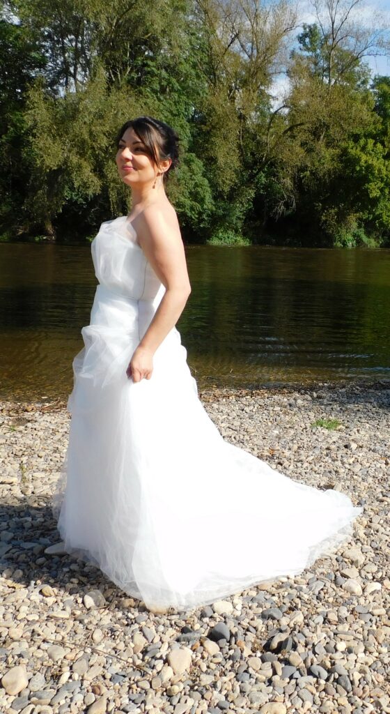 Les Précieuses- Robe de mariée Angelite vue de profil gauche. Bustier recouvert de tulle et tulle pailleté. Bas avec épaisseurs de tulle et un drapé de tulle pailleté.