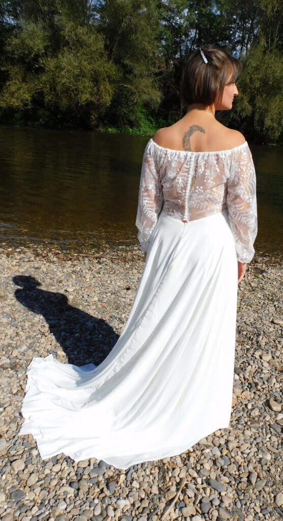 Les Précieuses - Robe de mariée Topaze vue de dos. Avec ses manche longue en dentelle et son encolure bateau. Le dos est fermé par une myriade de petits boutons.