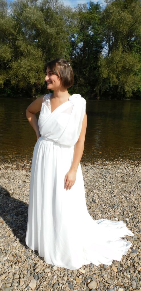 Les Précieuses- Robe de mariée Galène vue de face. Haut asymétrique en dentelle et mousseline drapée. Une ceinture recouverte de dentelle met en valeur la taille de la mariée.