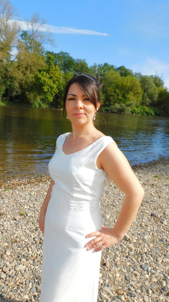 Les Précieuses - Robe de mariée Opale vue de face proche. épouse la silhouette avec sa forme prêt du corps et son col bénitier. La taille est relevée d'un galon de dentelle.