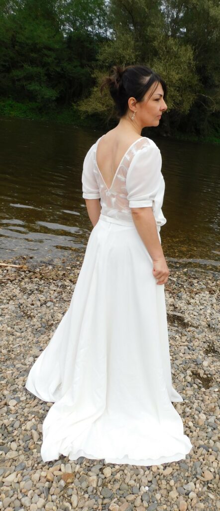 Les Précieuses - Ensemble pour mariée Grenat et Aventurine vus de 3/4 dos. Haut avec dos entièrement en dentelle. Manche en mousseline. Jupe longue en crêpe.