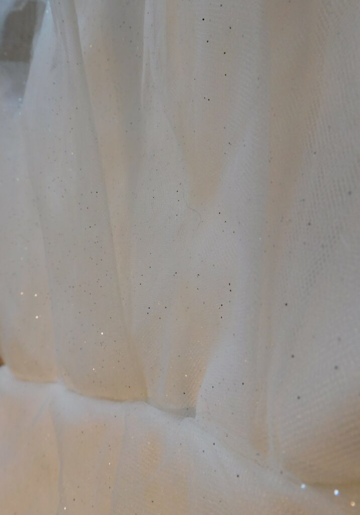 Robe de mariée Angèlite. bustier recouvert de tulle et tulle pailleté en forme de pétale. Bas de jupe avec 3 épaisseurs de tulle. vue de face proche