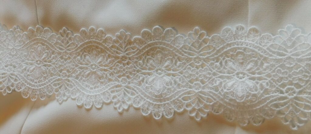 Les Précieuses - Robe de mariée Opale détail. épouse la silhouette avec sa forme prêt du corps et son col bénitier. La taille est relevée d'un galon de dentelle.