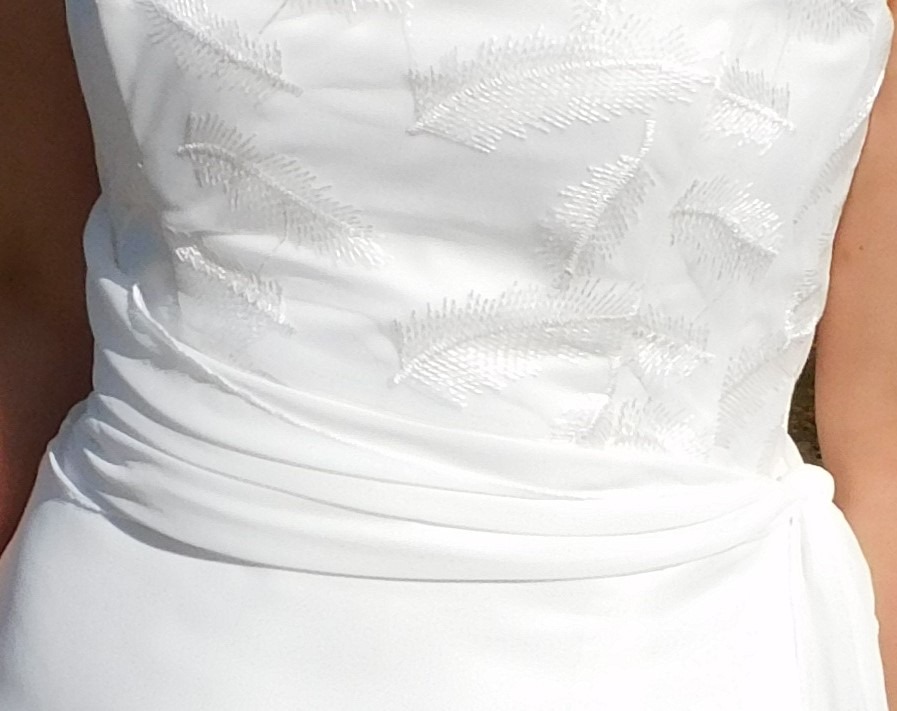 Découvrez la robe de mariée Ambre. Une robe légère et fluide en crêpe. Dentelle en tulle brodé sur le bustier et drapé de mousseline. Détail dentelle